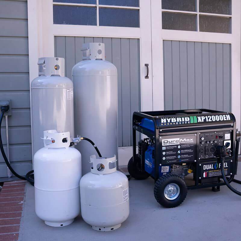 DuroMax XP12000EH Dual Fuel Generator Corner View With Different Sizes Of Propane