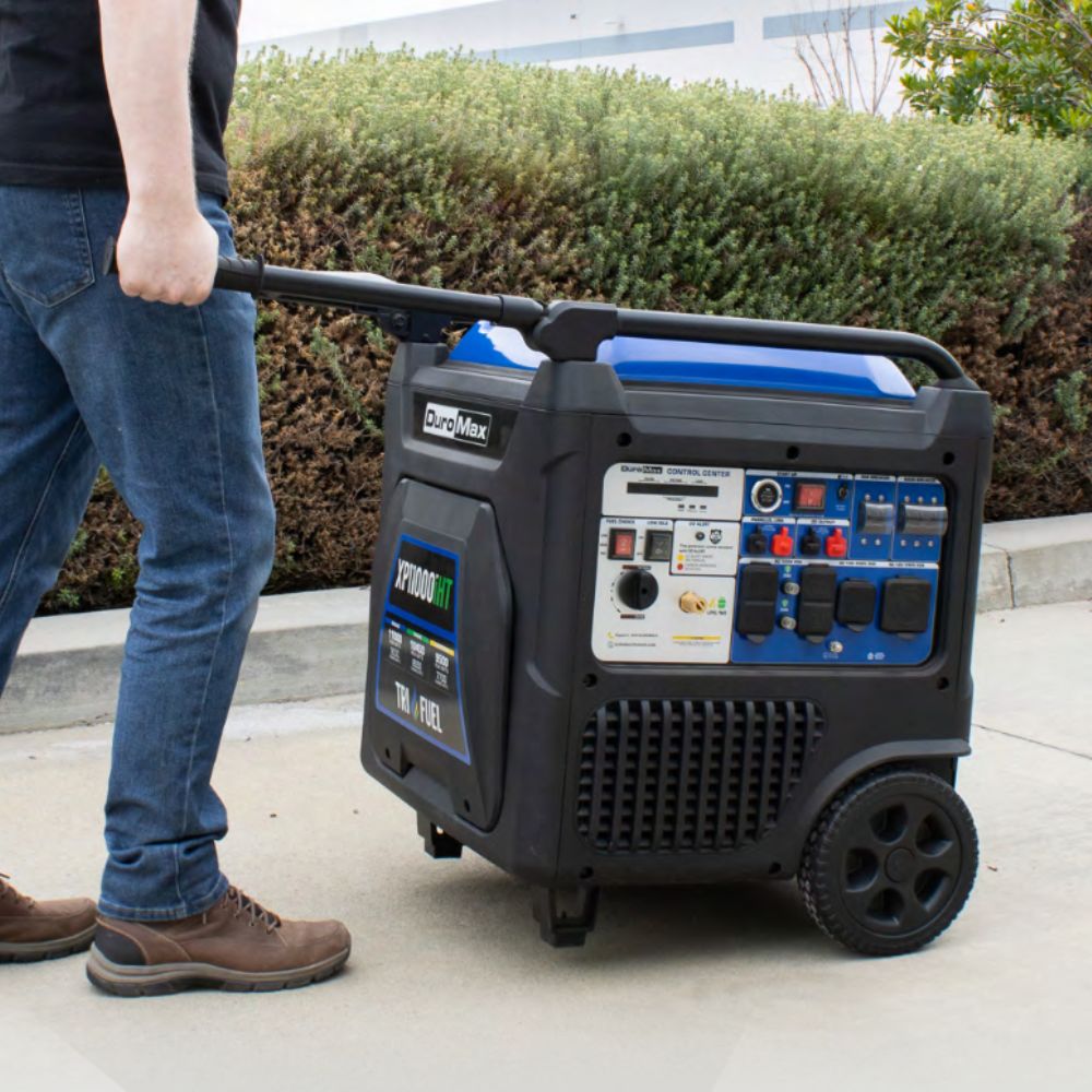 Duromax XP11000iHT Tri-Fuel Inverter Generator being pushed by a man wearing jeans
