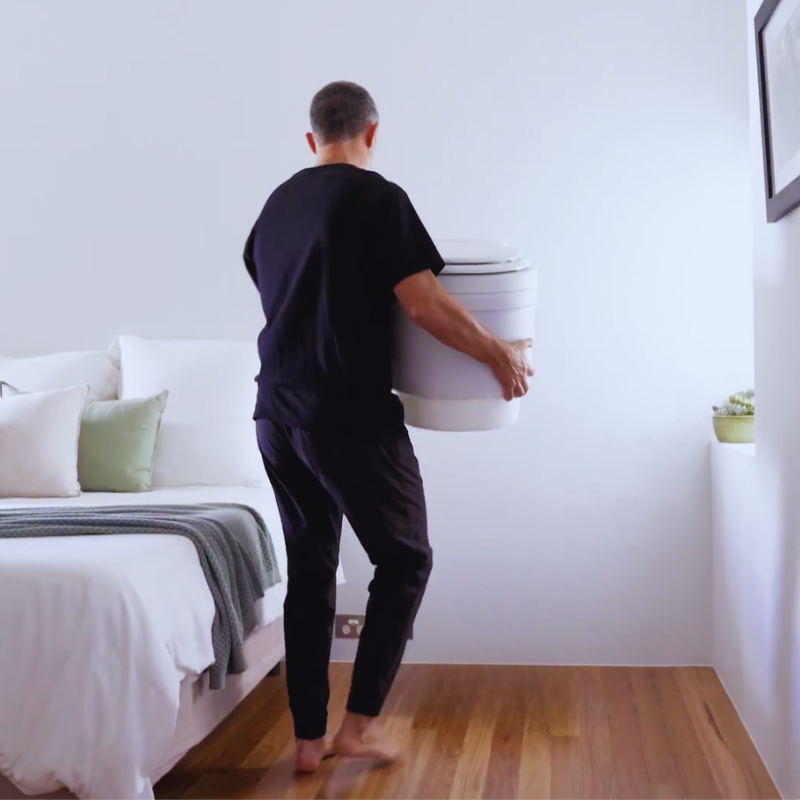 Man Carrying a Laveo Dry Flush Toilet